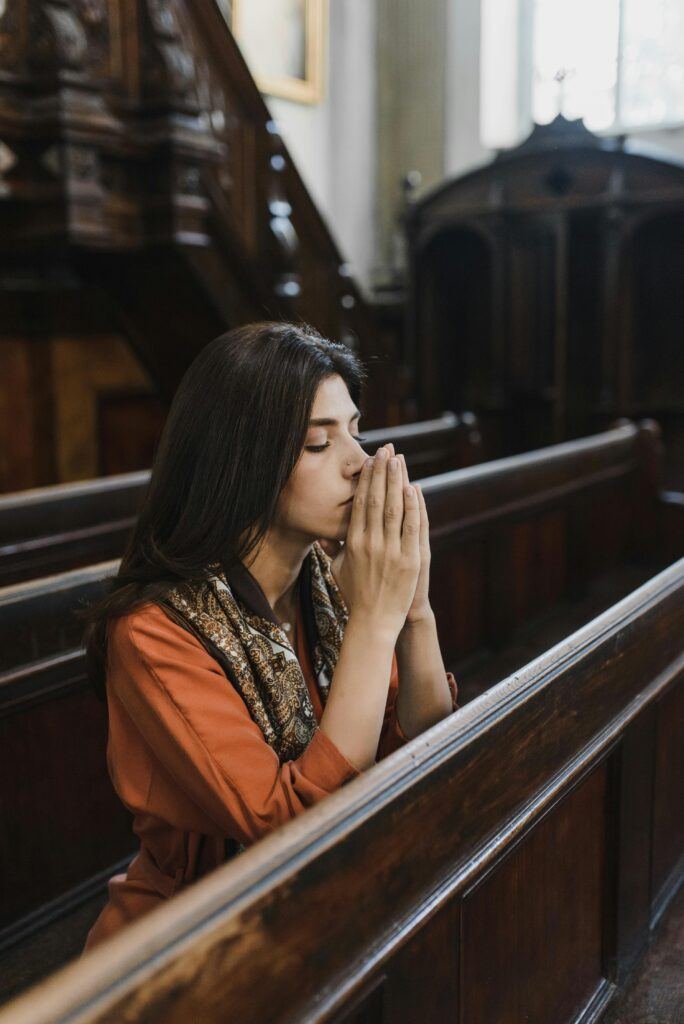 A woman in prayer in a church 